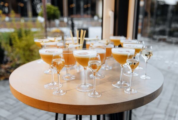 Round high-top cocktail table with glasses of cocktails at an outdoor event