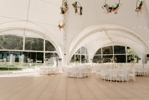 Wedding tent with smooth tiled flooring set with round tables and white chairs